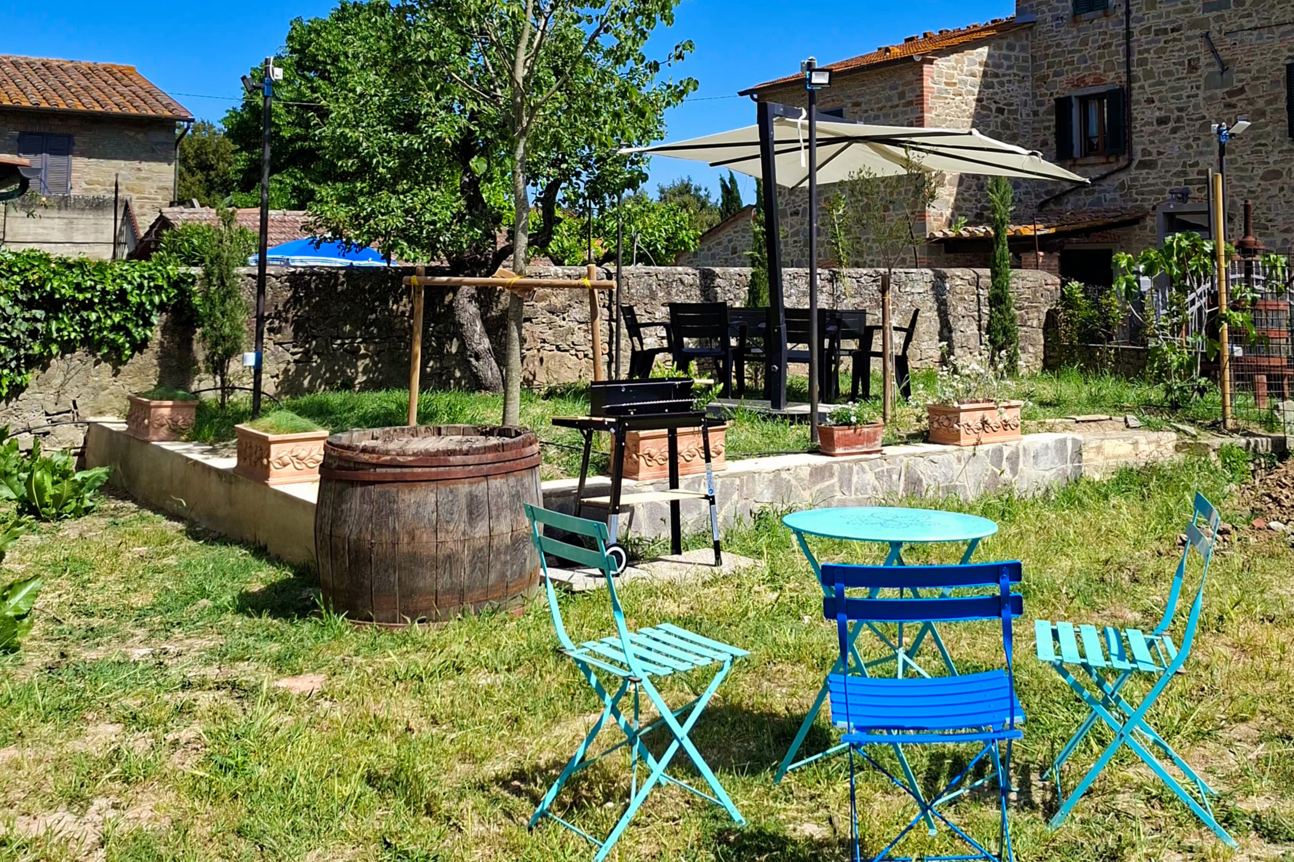 Giardino privato con sedute colorate e barbecue